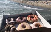 A box of Duck Donuts with the beach in the background.