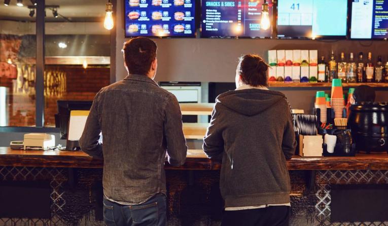 Two men choose food in a fast food restaurant.