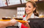 Restaurant worker hands food to a customer.