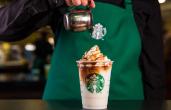 A Starbucks barista pours a shot of espresso into a drink.
