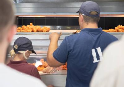 Staff inside a fast-food restaurant making chicken.